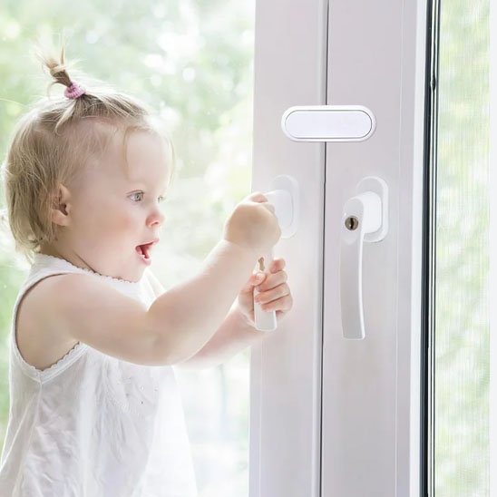 Bloque-porte bébé adhésif installé sur placard cuisine pour sécurité enfant