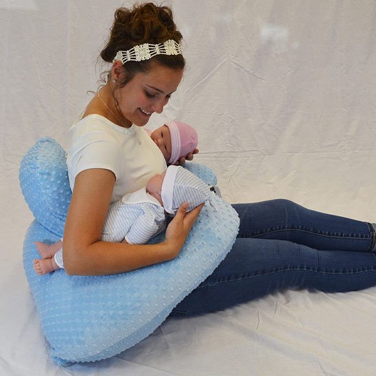 Maman utilisant un coussin d'allaitement ergonomique pour nourrir son bébé confortablement