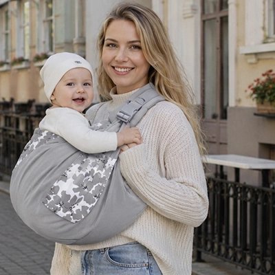Maman utilisant une écharpe de portage pour porter bébé"