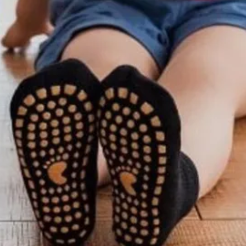 Petit garçon marchant avec des chaussettes antidérapantes bébé