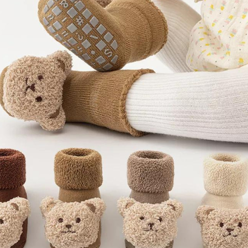 Bébé heureux portant des chaussettes antidérapantes confortables